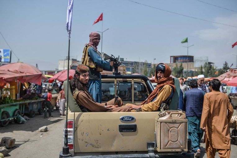 Taliban fighters ride a pickup truck near the Koht-e Sangi market in western Kabul on Tuesday morning.  Statue of Hushang Hashemi / AFP