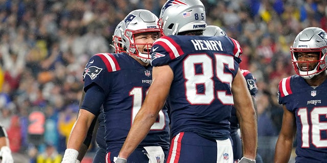 New England Patriots quarterback Mac Jones, left, celebrates after his touchdown pass to the tight end Hunter Henry (85) during the first half of an NFL football game against the Tampa Bay Buccaneers, Sunday, October 3, 2021, In Foxboro, Massachusetts.