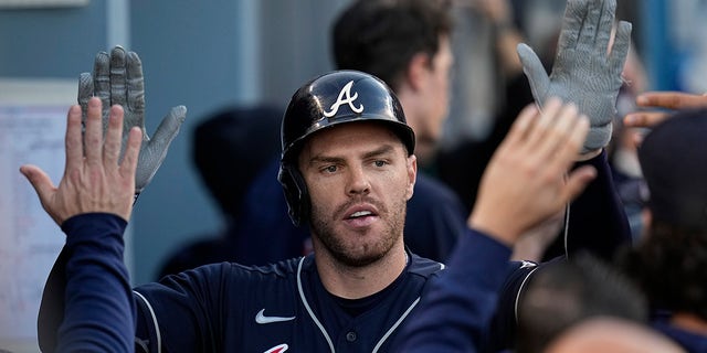 Atlanta Braves' Freddy Freeman is congratulated after he hit a home double during the first inning against the Los Angeles Dodgers in Game Five of the National League Baseball Championship Series on Thursday, October 21, 2021, in Los Angeles. 