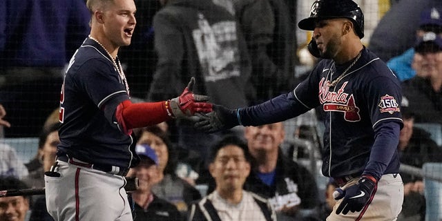 Atlanta Braves player Eddie Rosario, right, congratulates the Atlanta Braves, Jock Pederson, after he scored two goals in the ninth inning against the Los Angeles Dodgers in Game 4 of the National League Baseball Championship Series on Wednesday, October 20, 2021, in Los Angeles.