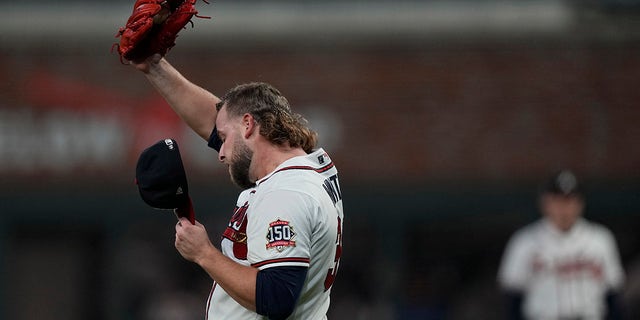 Atlanta Braves relaxed AJ Minter wipes his face after giving up Houston Astros' RBI double Marwen Gonzalez during the fifth inning of Game 5 of the World Series Baseball between the Houston Astros and Atlanta Braves Sunday, October 31, 2021, in Atlanta.