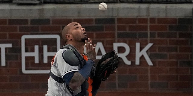 Houston Astros player Martin Maldonado picks up a hit from the Atlanta Braves' AJ Minter during the fourth inning in Game Five of the World Baseball Championship between the Houston Astros and the Atlanta Braves on Sunday, Oct. 31, 2021, in Atlanta.