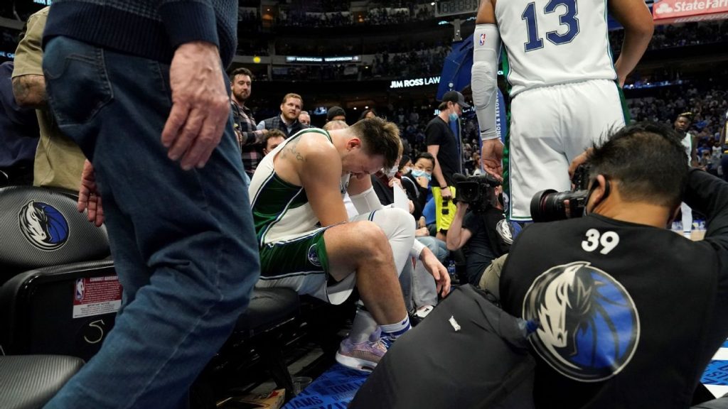 Dallas Mavericks star Luka Doncic walks off the field with a left ankle injury after defeating the Nuggets