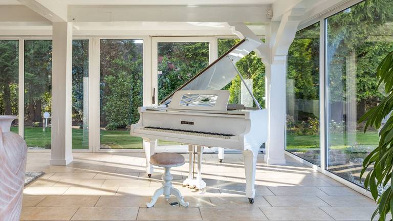 The white grand piano in the garden room (Photo: Fonda)