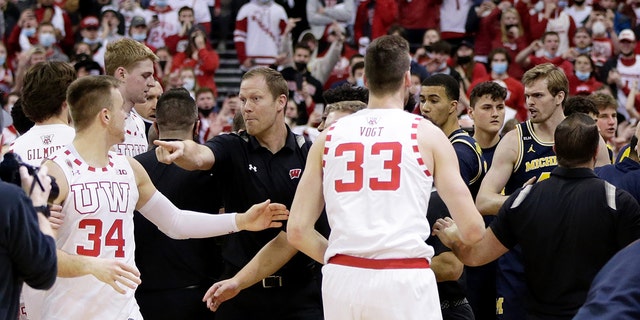 Wisconsin Badgers assistant coach Joe Krabenhoft reacts after a fight broke out between the Wisconsin Badgers and Michigan Wolverines.  Joe Krabenhoft is hit in the head by Michigan Wolverines coach Joan Howard at the Cole Center on February 20, 2022, in Madison, Wisconsin.