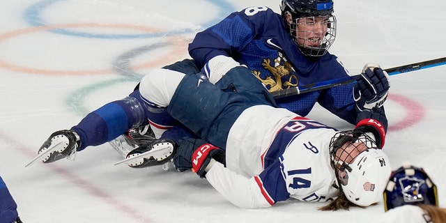 The United States' Brianna Decker (14) lies on the ice after colliding with Finland's Ronja Savolainen (88) during a preliminary round women's hoc game at the 2022 Winter Olympics, Thursday, Feb.  3, 2022, in Beijing.