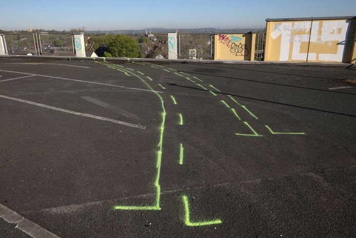 A large hole can be seen in the boundary grids on the top floor of a parking garage in Essen.  The yellow markings indicate the path the car took before it crashed.
