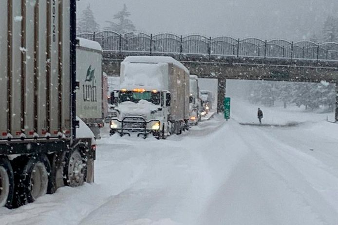 Trucks get stuck in the snow on the highway.