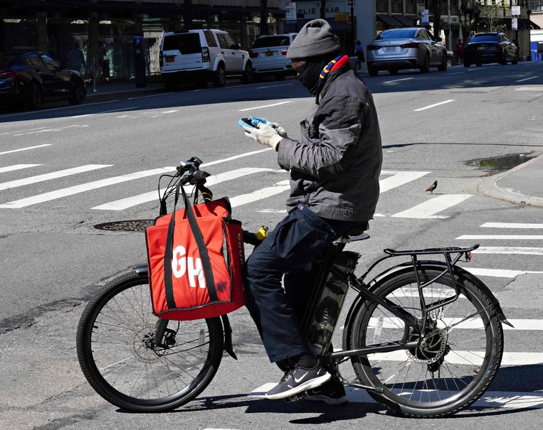 The courier of American food delivery service Grubhub checks his phone on a street in New York.  Image AFP