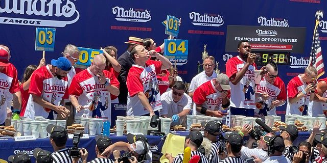 Contestants compete to see who can eat the most hot dogs during the famous Nathan's Hot Dog Eating Contest in Coney Island on July 4, 2022.