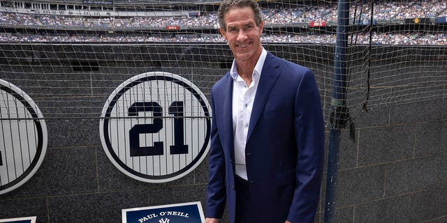 Retired New York Yankees player Paul O'Neill stands next to his number at Memorial Park during a retirement party before a baseball game between the Yankees and the Toronto Blue Jays, Sunday, August 21, 2022, in New York.