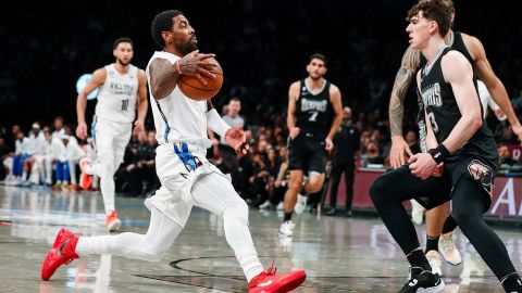 Brooklyn Nets guard Kyrie Irving, left, dribbles against Memphis Grizzlies forward Jake LaRavia during the first half on Sunday, November 20, 2022 in New York. 