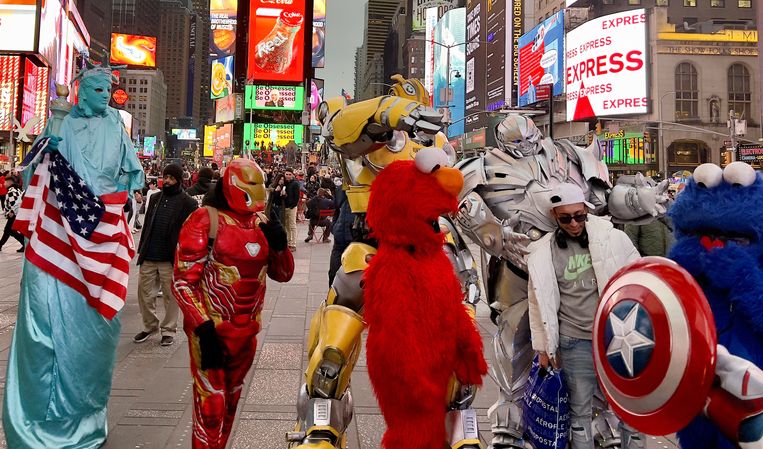 Tourists entertain themselves in New York's Time Square with cosplayers — people dressed as movie or video game characters.  A cheaper dollar makes vacationing in America more attractive.  Image by Daniel Slim / ANP