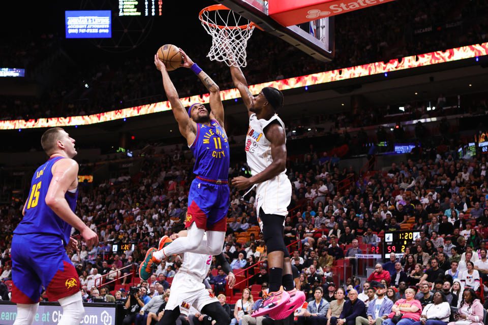 Bruce Brown #11 of the Denver Nuggets takes a dunk against Jimmy Butler #22 of the Miami Heat during the second quarter of the game at Miami-Dade Arena on February 13, 2023 in Miami, Florida.  Note to User: User expressly acknowledges and agrees that, by downloading or using this image, User agrees to the terms and conditions of the Getty Images license agreement.  (Photo by Megan Briggs/Getty Images)