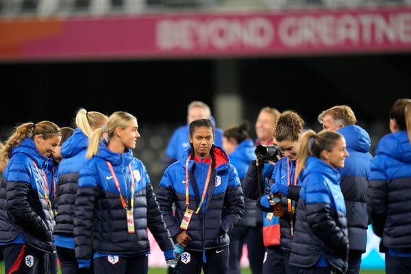 Netherlands players wear black and blue puffy jackets. 