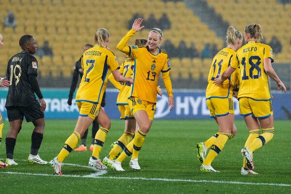 Sweden's Amanda Elstest, in number 13, claps hands with Jona Andersson in celebration of her team's first goal.