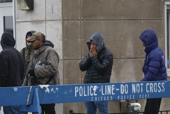 A group of migrants receive food outside a migrant landing zone during a winter storm in Chicago, Illinois on January 12, 2024.