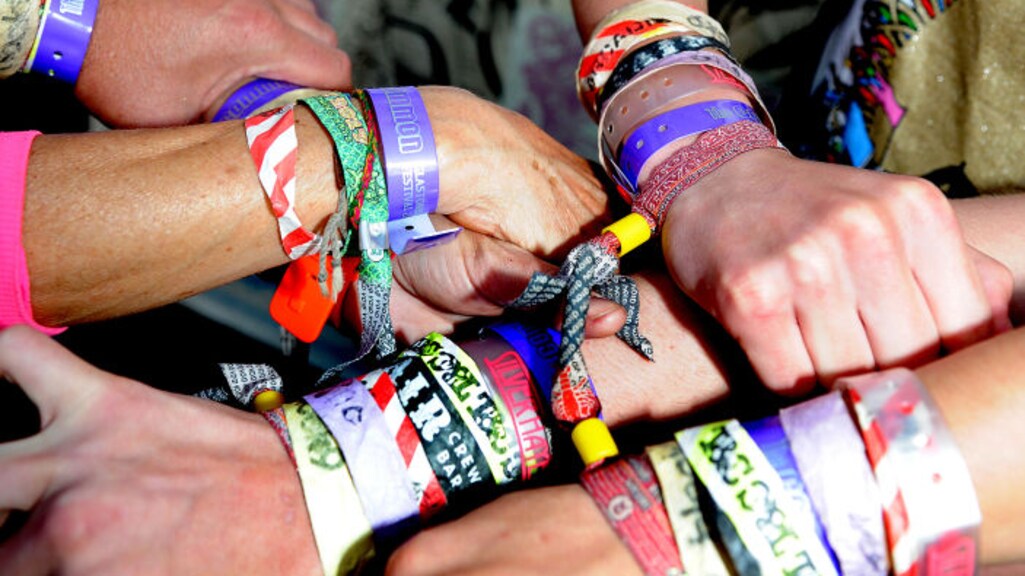 Arms full of festival bands, during the British Glastonbury Festival. 